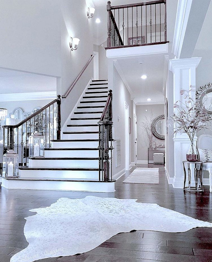 Una sala de estar en colores claros de estilo neoclásico llena de lujo y sofisticación.