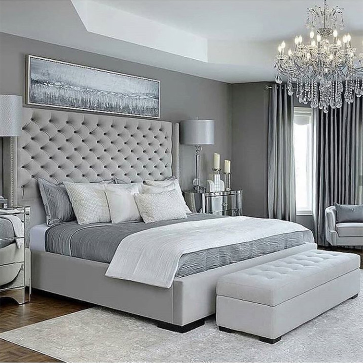 Un dormitorio neoclásico en colores grises. En el centro de la composición del dormitorio neoclásico hay una cama alta con un cabecero suave y alto.
