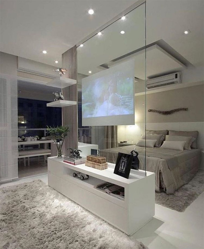 Un dormitorio moderno en blanco: muebles blancos, vidrio, alfombras. Interior blanco y beis.
