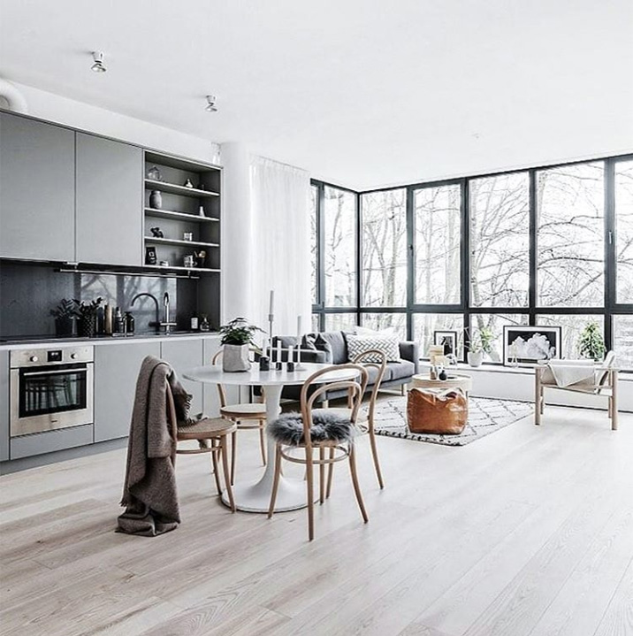 Una sala de estar escandinava abierta al resto de la casa con un ventanal. Una de las combinaciones modernas es la calidez de la madera con la frialdad del vidrio. Fotos de decoración nórdica.